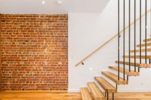 Custom made floating staircase with recycling hardwood and exposed original brick wall